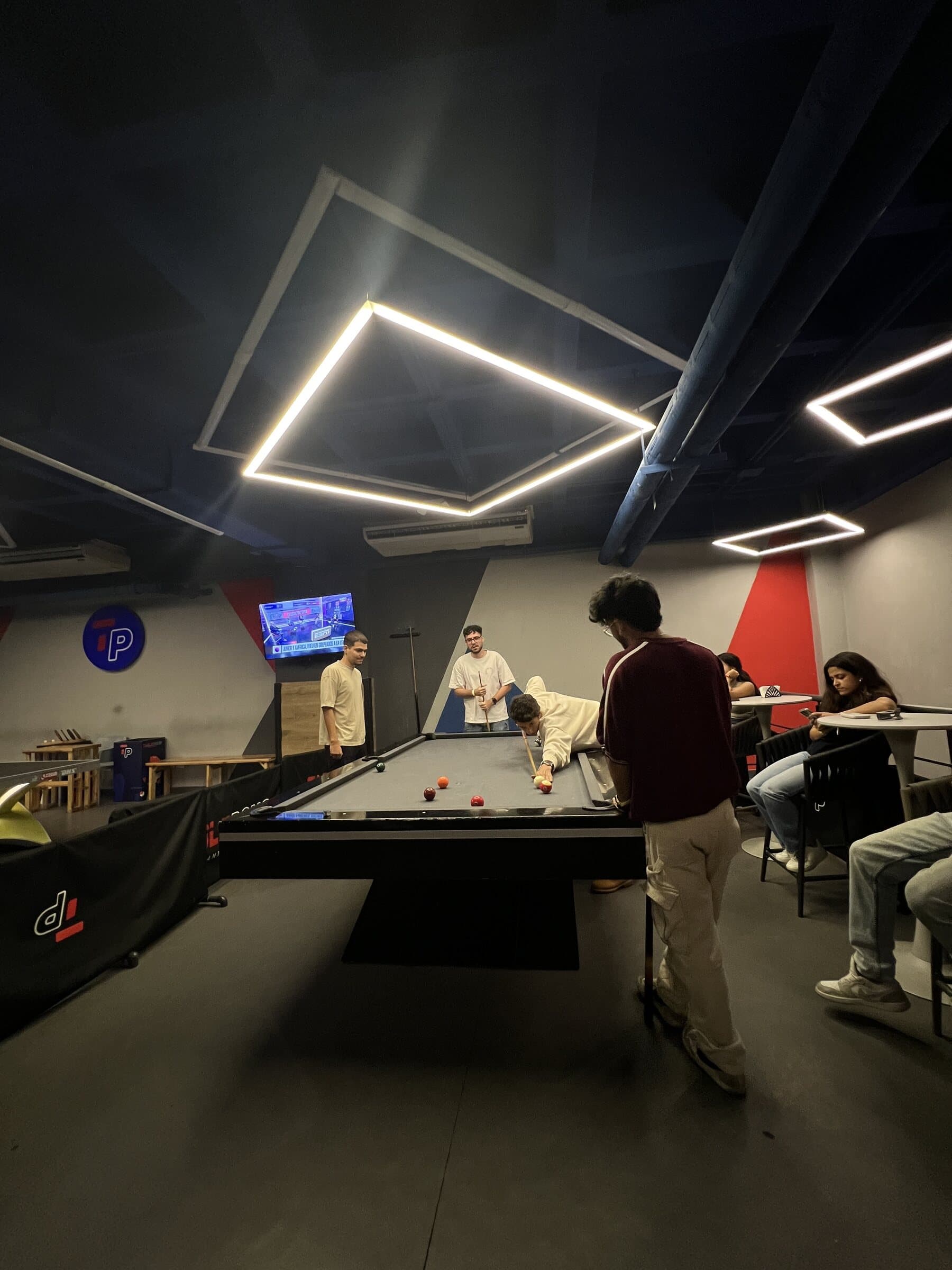 Mesa de pool con jugadores bajo iluminación LED